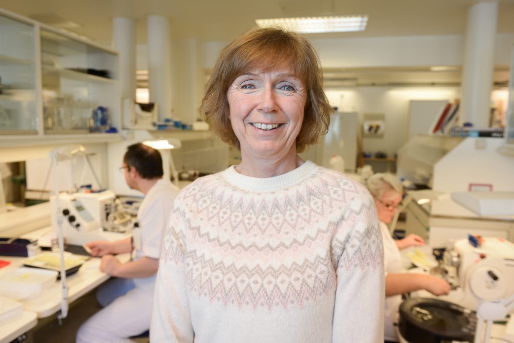 En person som smiler i et rom