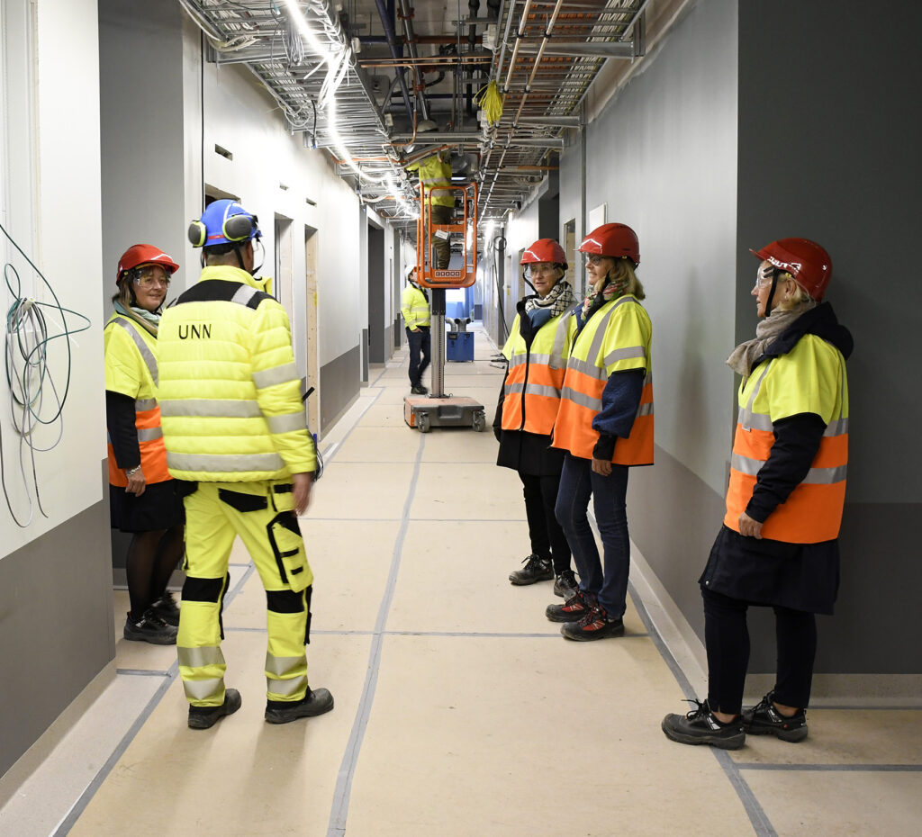 En gruppe mennesker i vernevester i en fabrikk