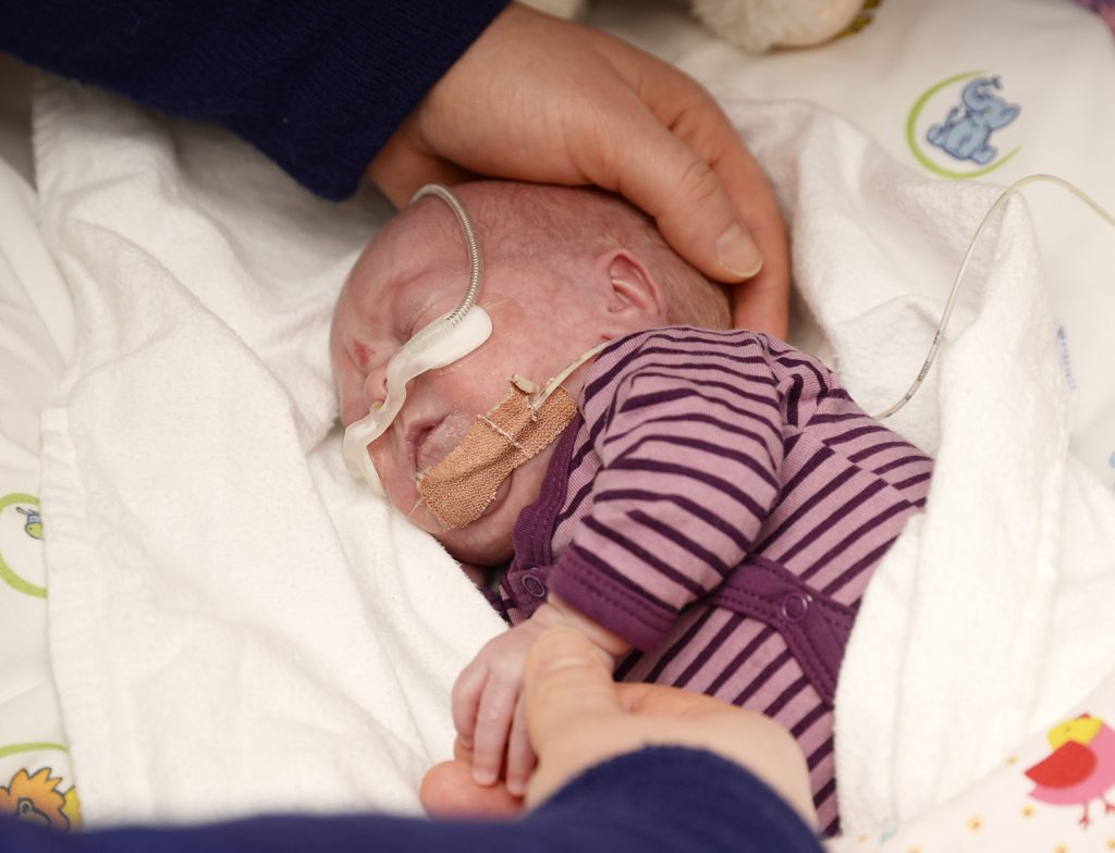 En baby med en skje i munnen