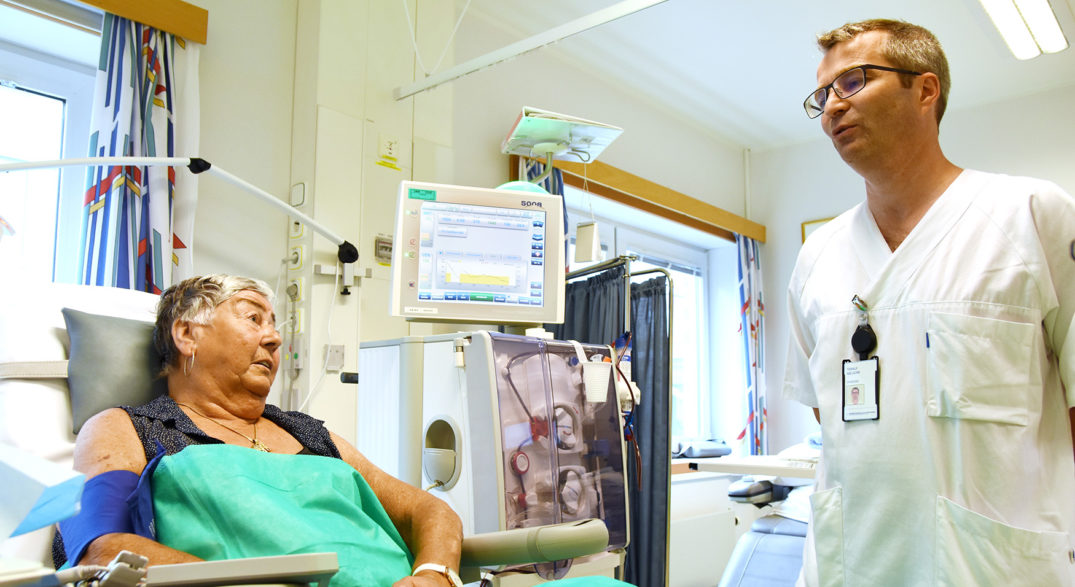 En lege som snakker med en pasient