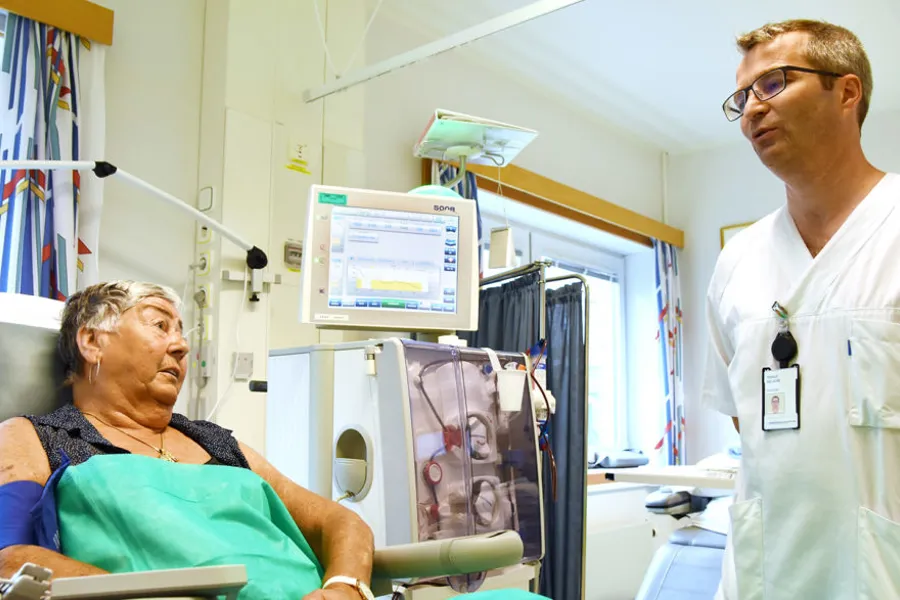 En lege som snakker med en pasient