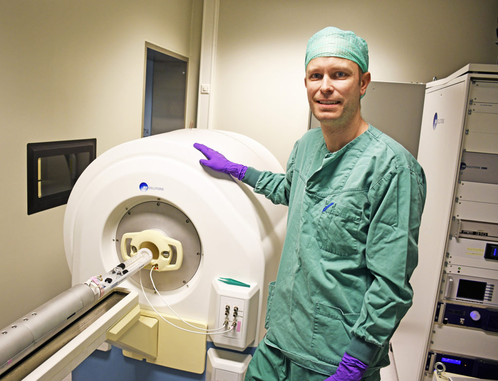 En person i laboratoriefrakk som holder en hvit gjenstand