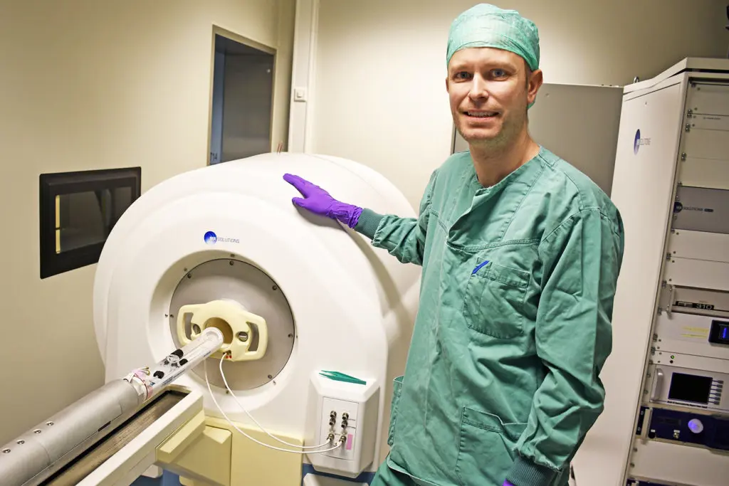 En person i laboratoriefrakk som holder en hvit gjenstand