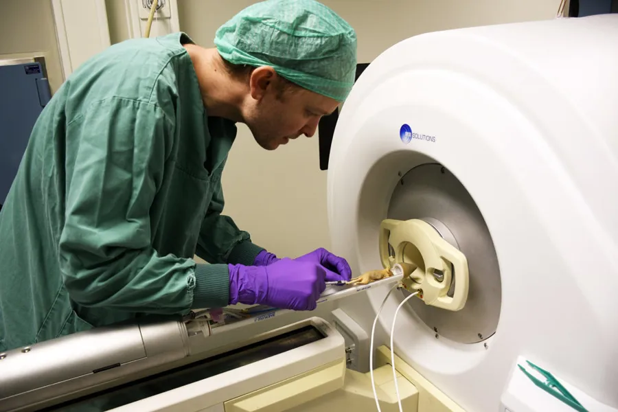 En mann i grønn frakk som ser på en maskin