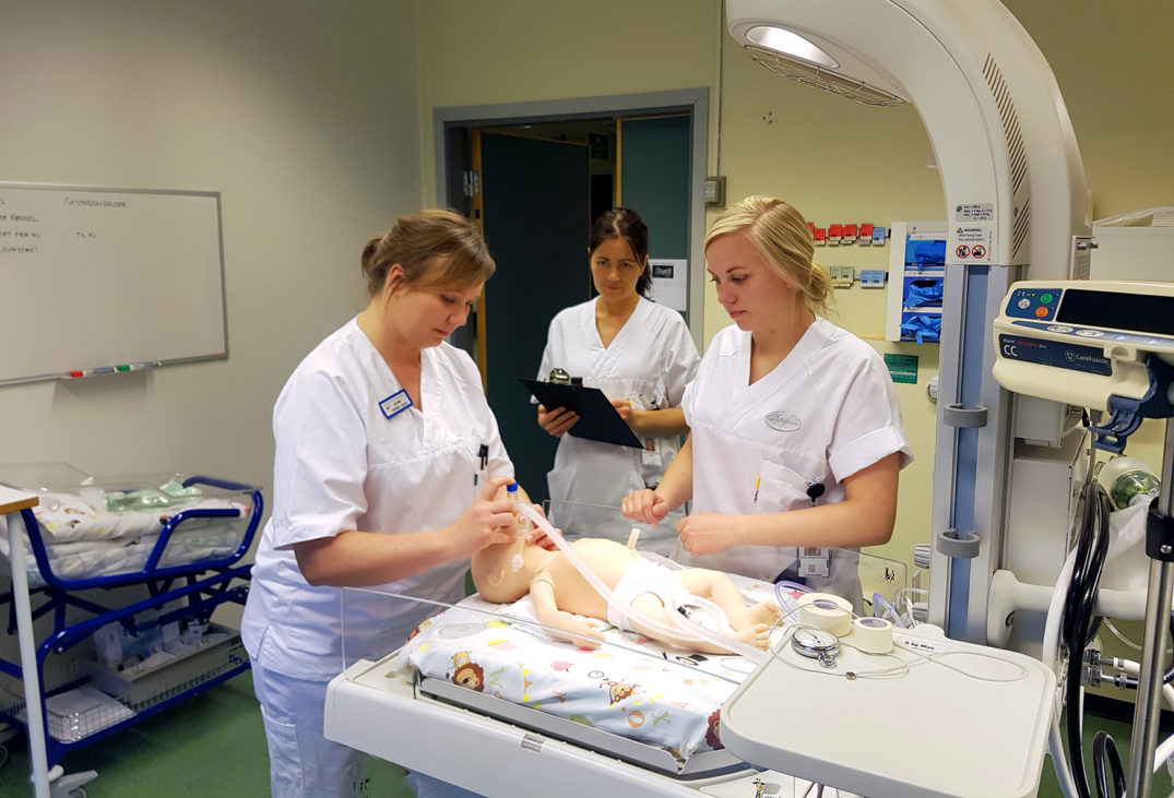 En gruppe kvinner i hvite frakker som jobber i et rom