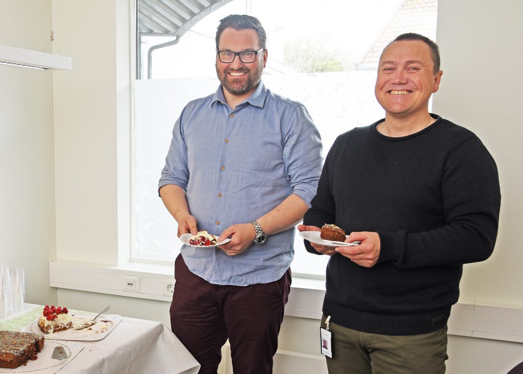 Et par menn som holder tallerkener med mat