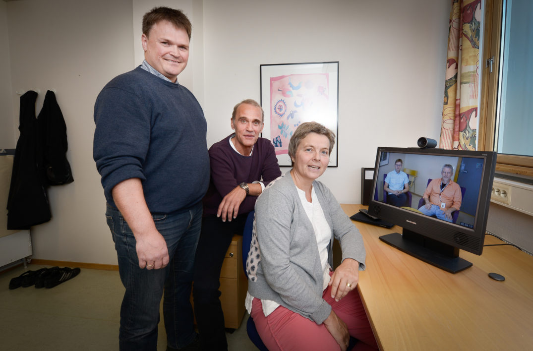 En gruppe mennesker som står foran en TV