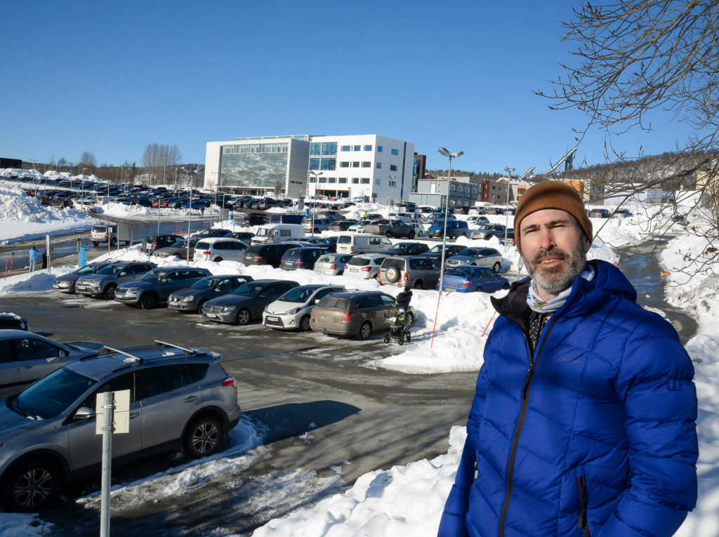 En person som står på en parkeringsplass