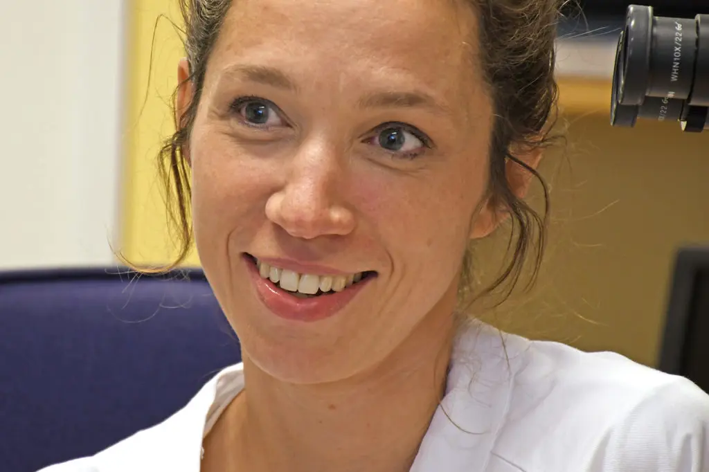 En kvinne som smiler til kameraet