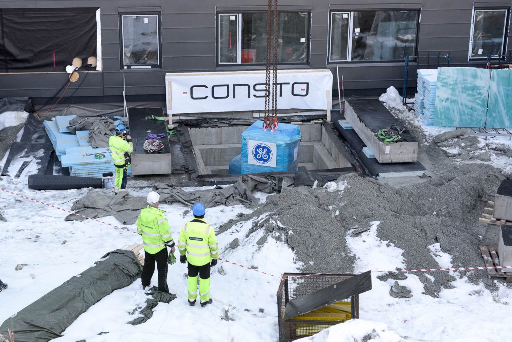 En gruppe mennesker i gule jakker som står i snøen