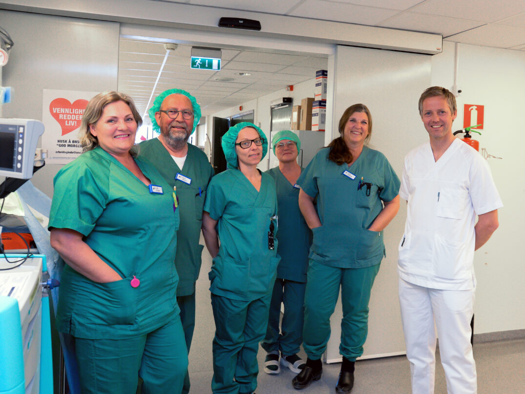 En gruppe mennesker i kirurgiske uniformer poserer for et bilde