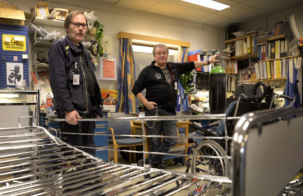 Et par menn som står ved siden av en handlevogn i en butikk