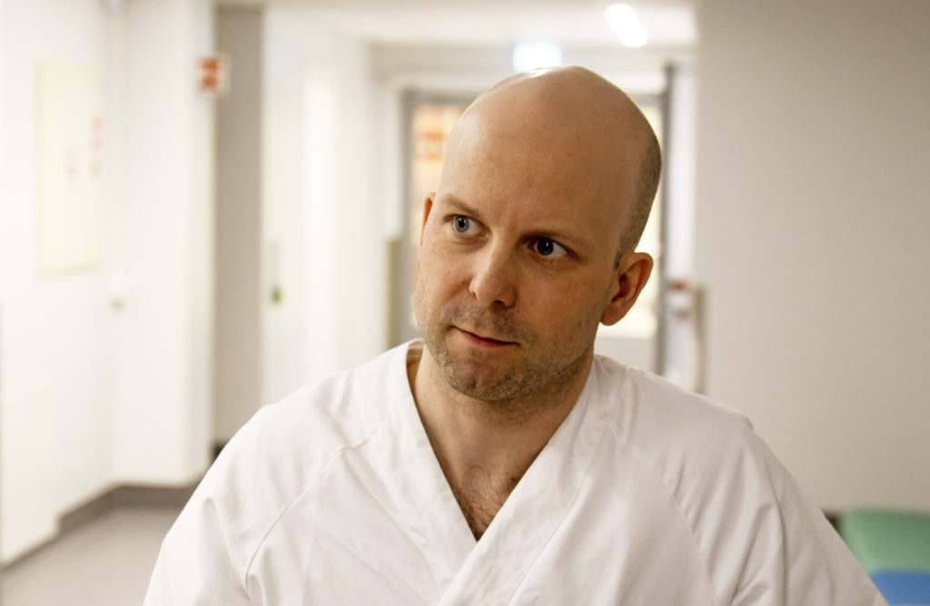 En skallet mann i hvit skjorte