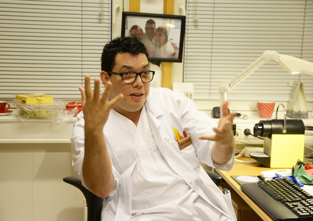 En mann som sitter ved et skrivebord med hendene i været