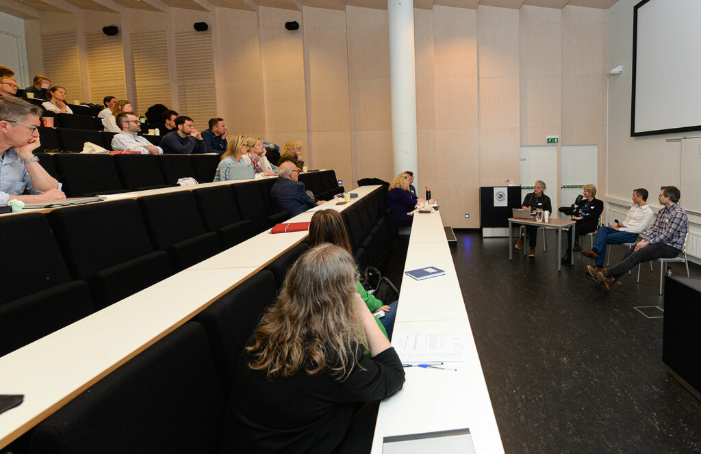 Forelesningssal med panel i front