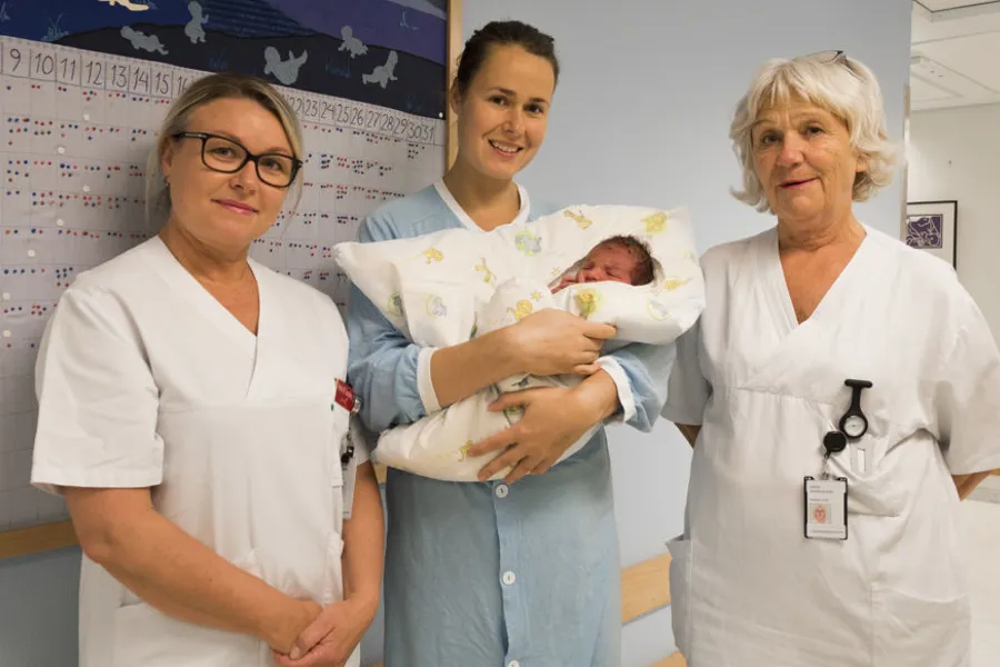 En gruppe kvinner som holder en baby