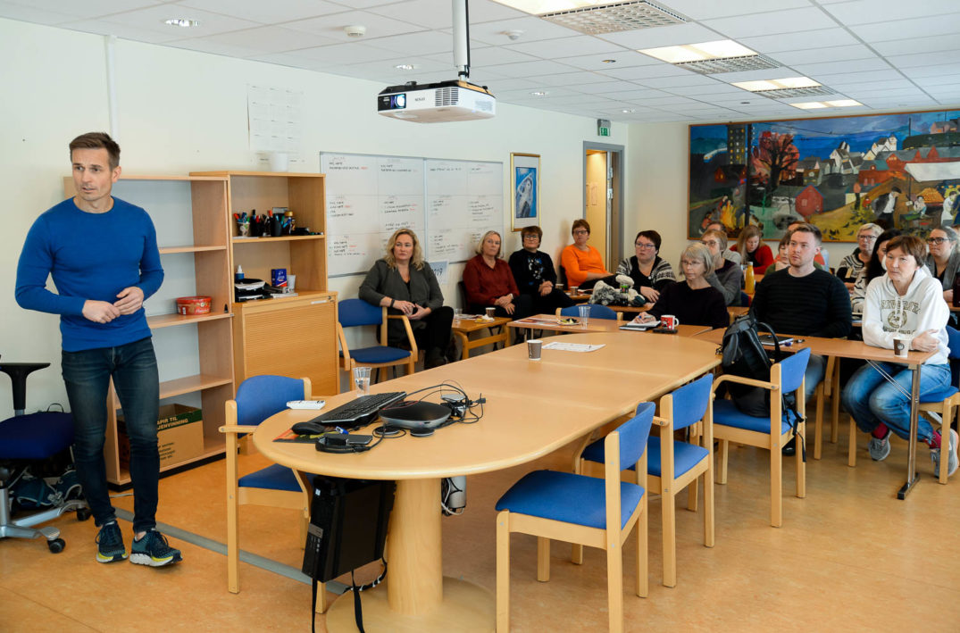 En person som står foran et klasserom fullt av elever