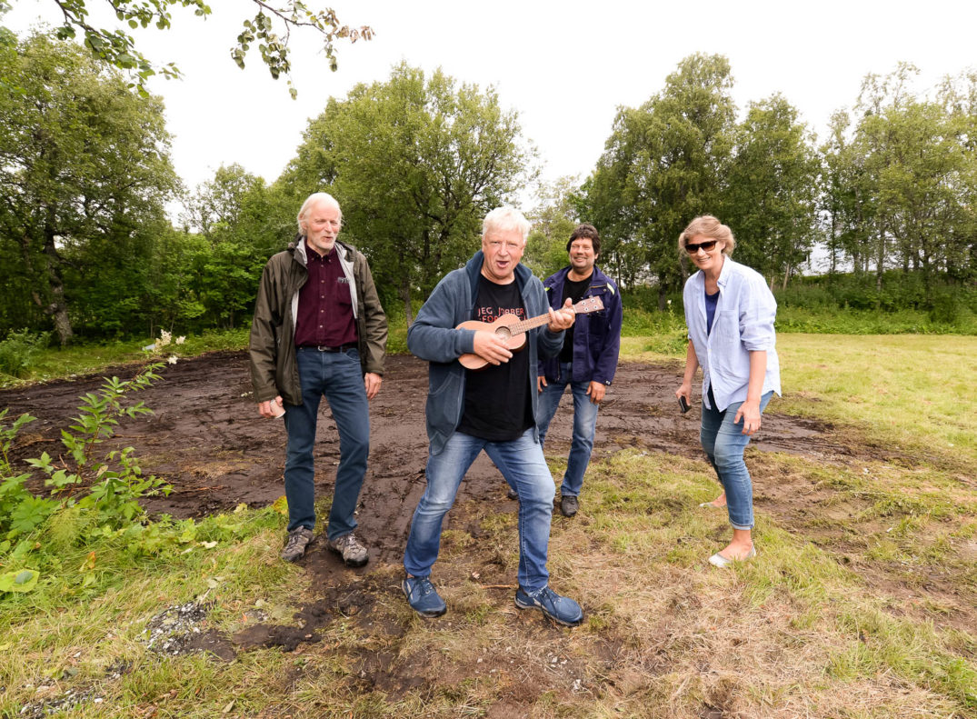 En gruppe mennesker som står på et jorde