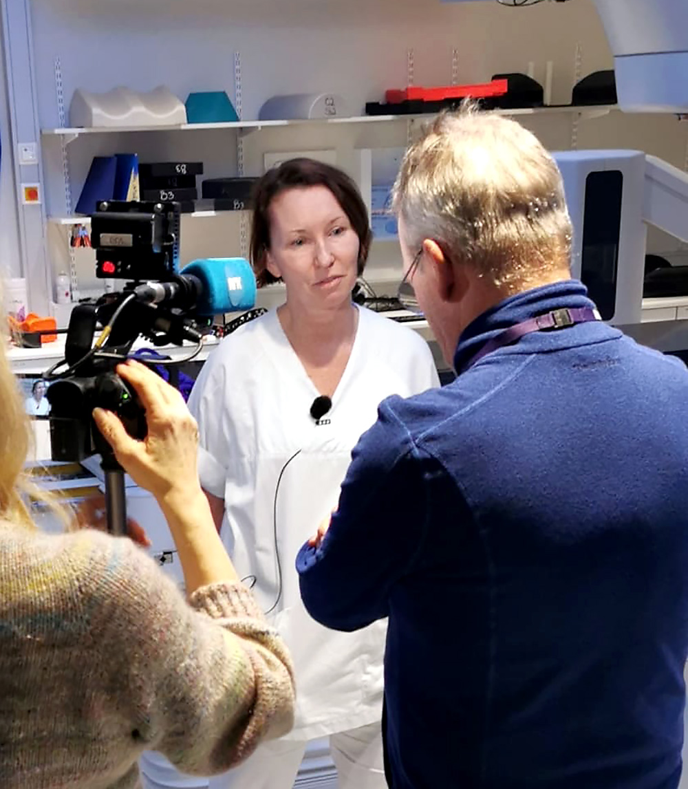 En kvinne som tar bilde av en mann i hvit frakk