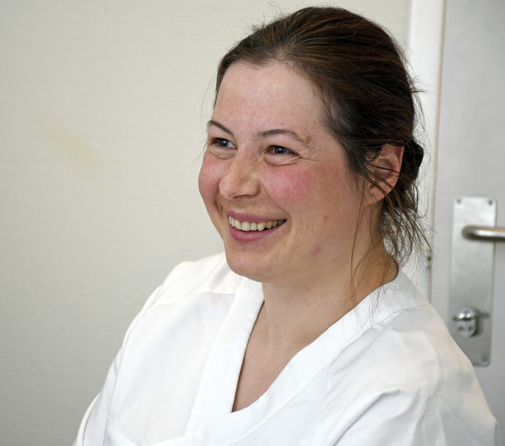 En kvinne som smiler til kameraet