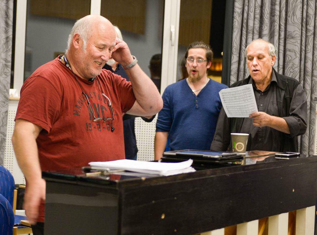 En gruppe menn som står ved et bord med papirer og en kopp