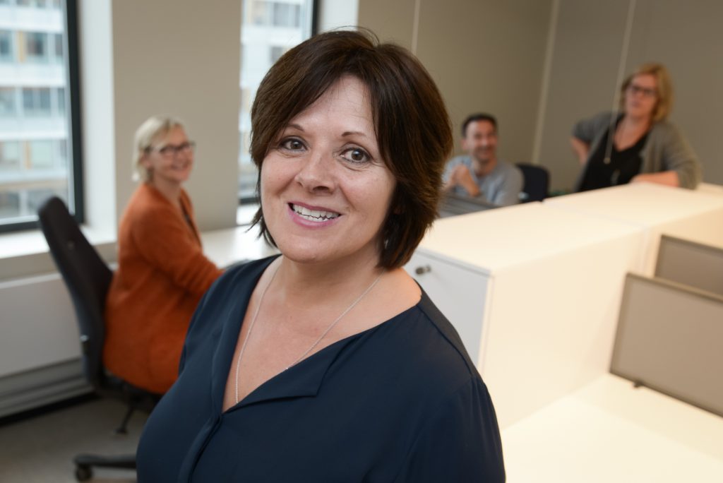 En kvinne som smiler til kameraet