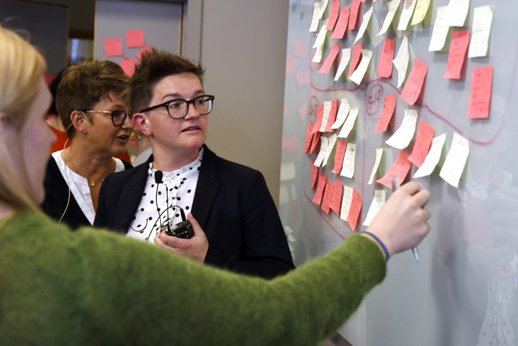 En gruppe mennesker som ser på en whiteboard