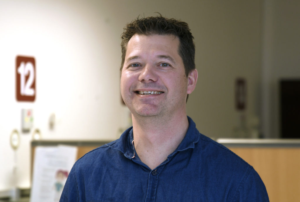 En mann som smiler til kameraet