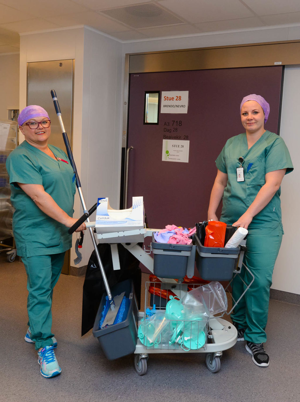 Et par kvinner i scrub-klær som holder en baseballkølle