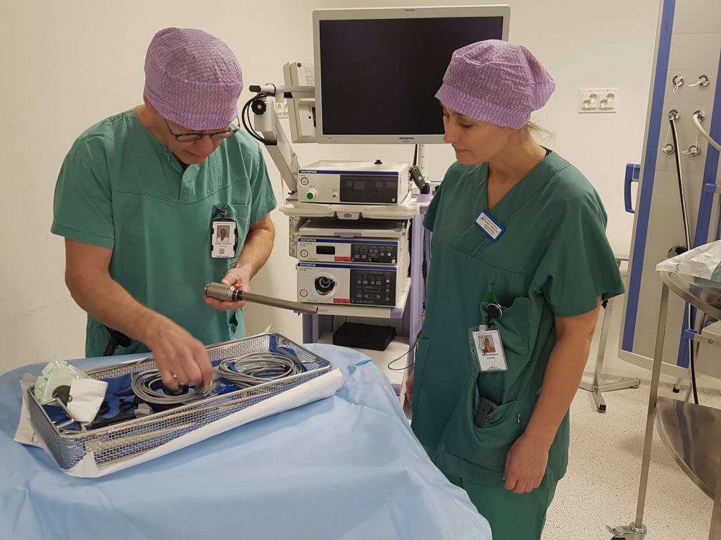 Et par kvinner i arbeidsklær som jobber på en maskin