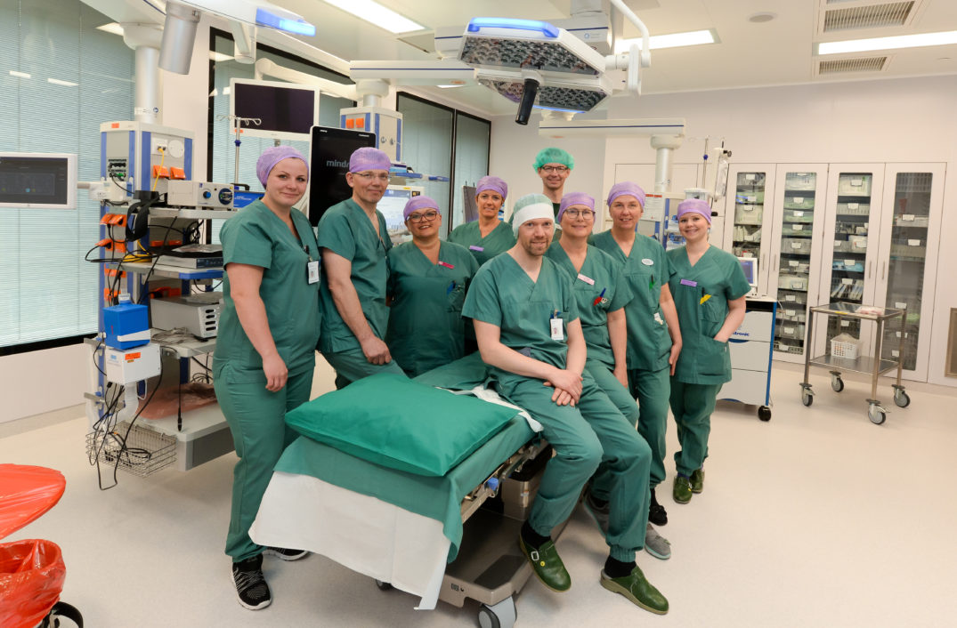 En gruppe mennesker i kirurgiske uniformer poserer for et bilde