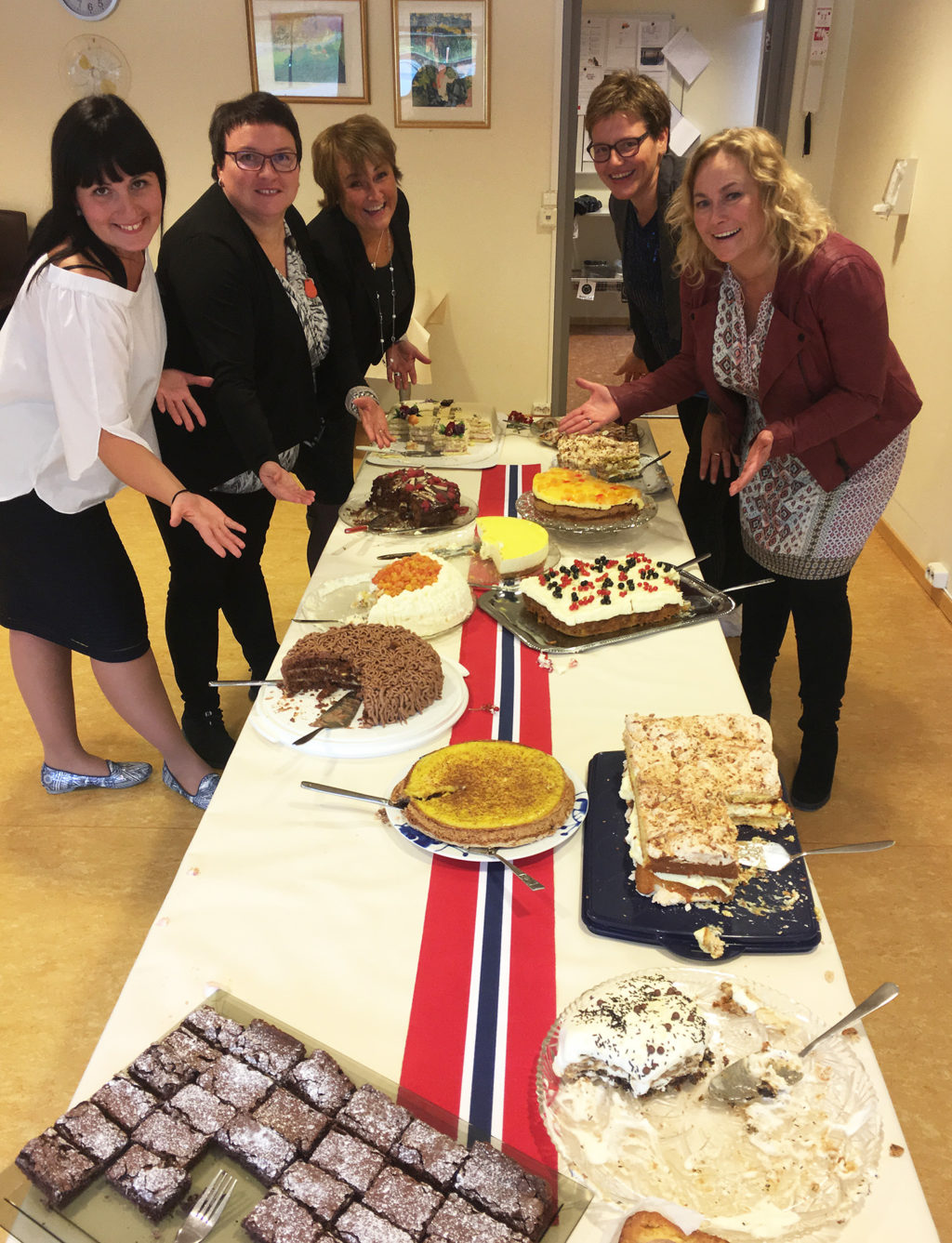 En gruppe mennesker som står rundt et bord med mat på