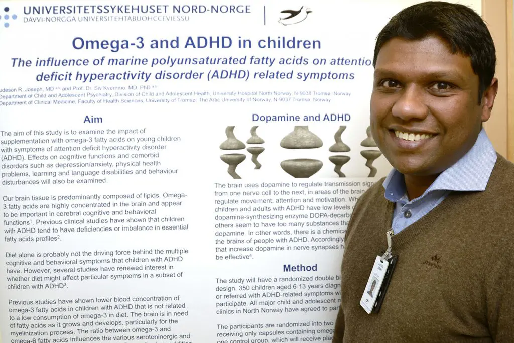 En mann som smiler foran en side med bein