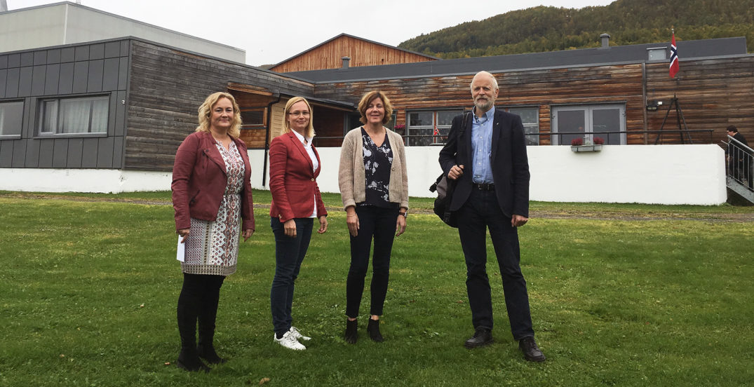 En gruppe mennesker som står foran en bygning