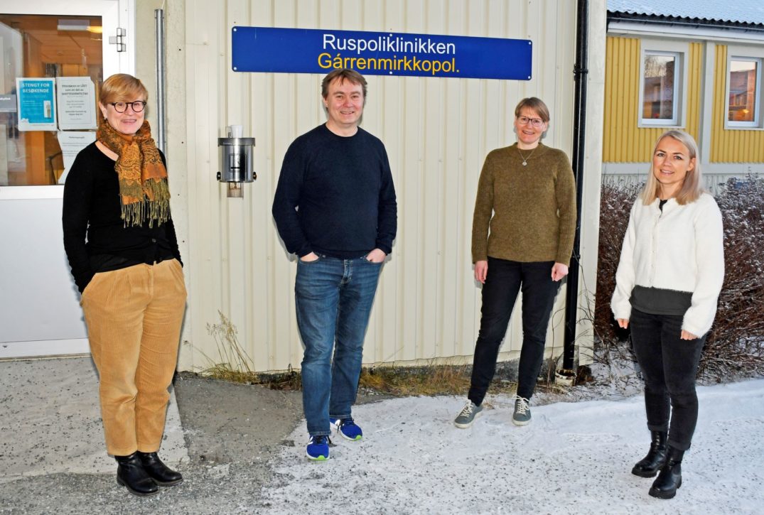 En gruppe mennesker som står foran en bygning