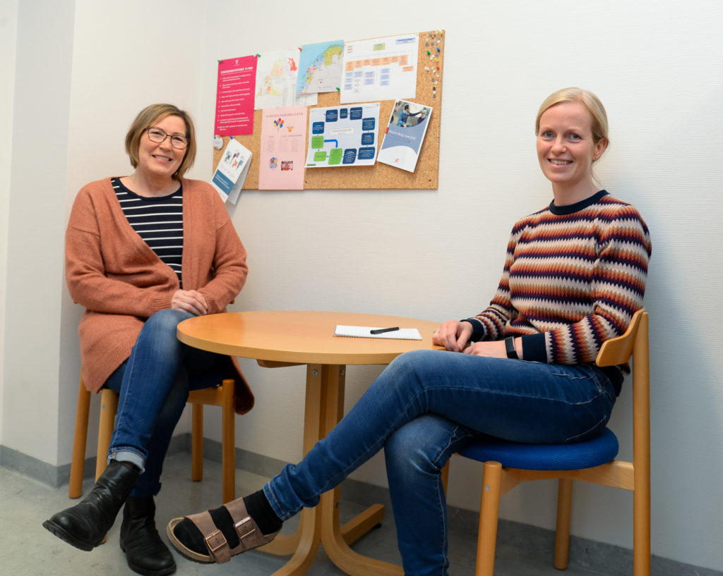 Et par kvinner som sitter ved et bord