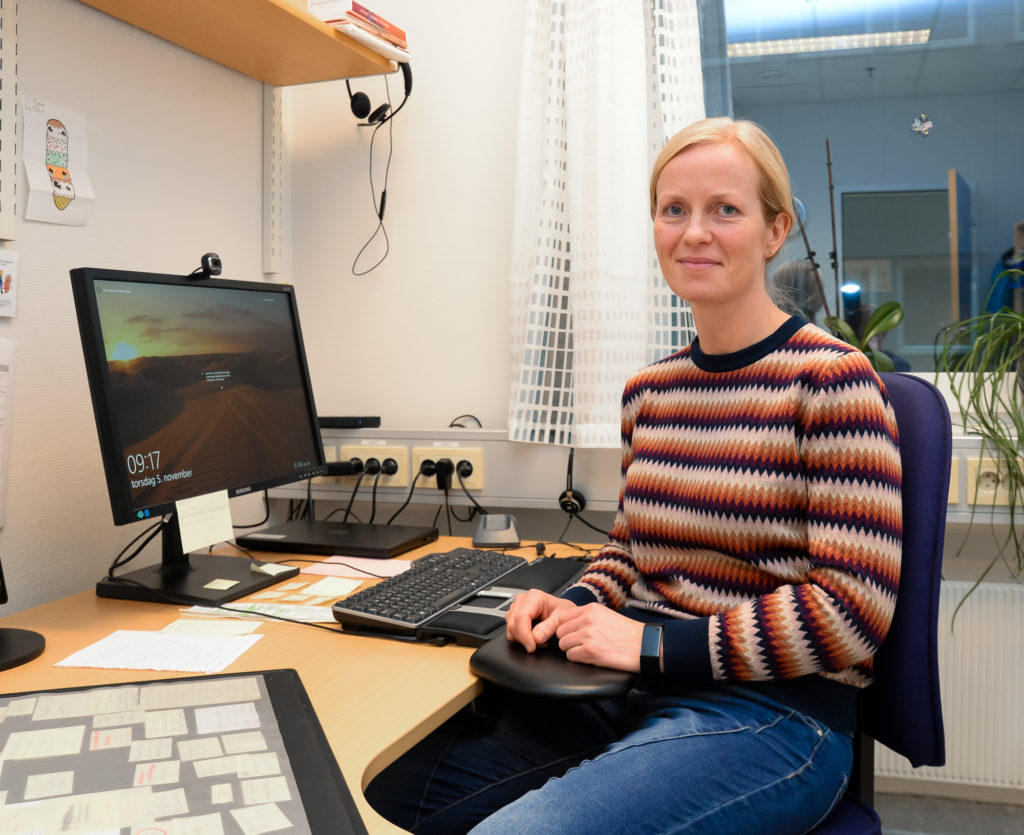 En person som sitter ved et skrivebord med en datamaskin