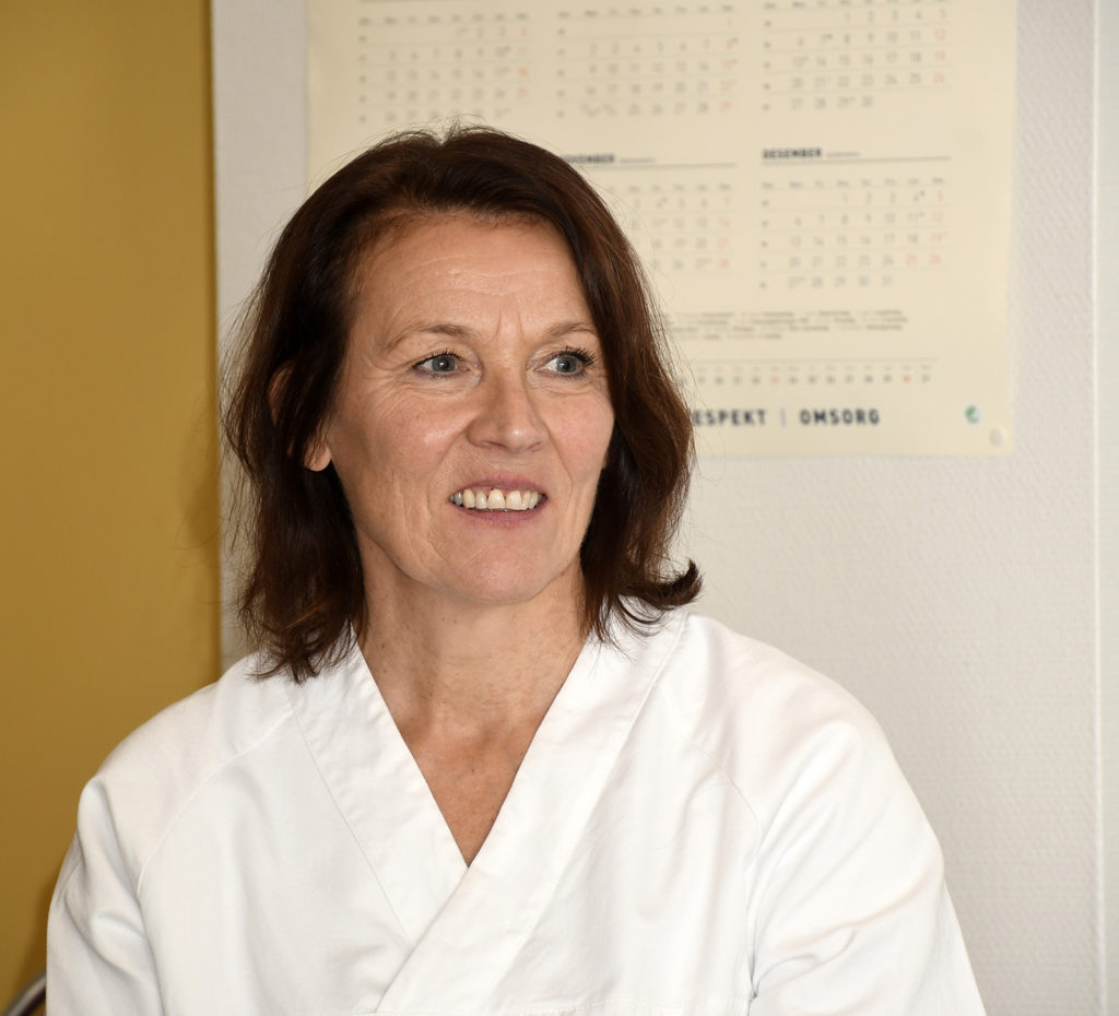 En person som smiler foran en whiteboard