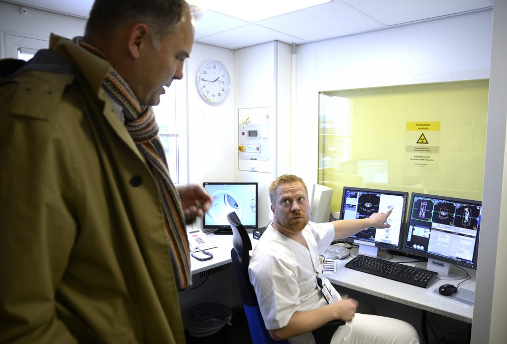 En mann som viser en mann noe på datamaskinen