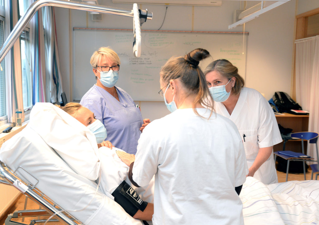 En gruppe mennesker i kirurgiske uniformer og masker