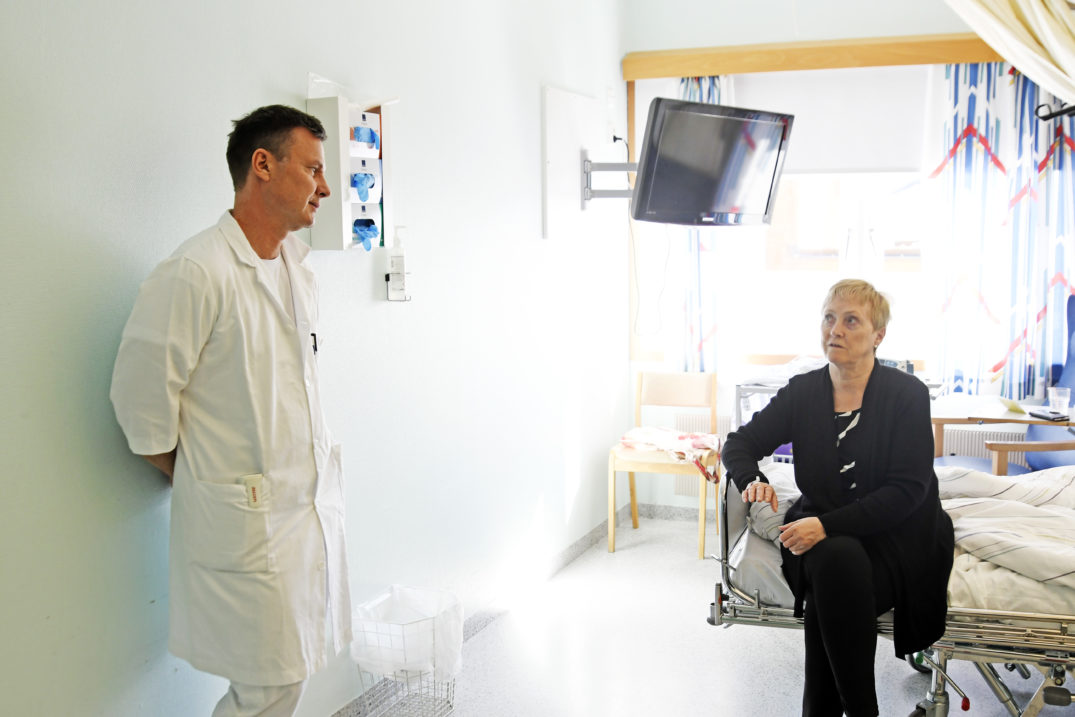 En lege som snakker med en pasient