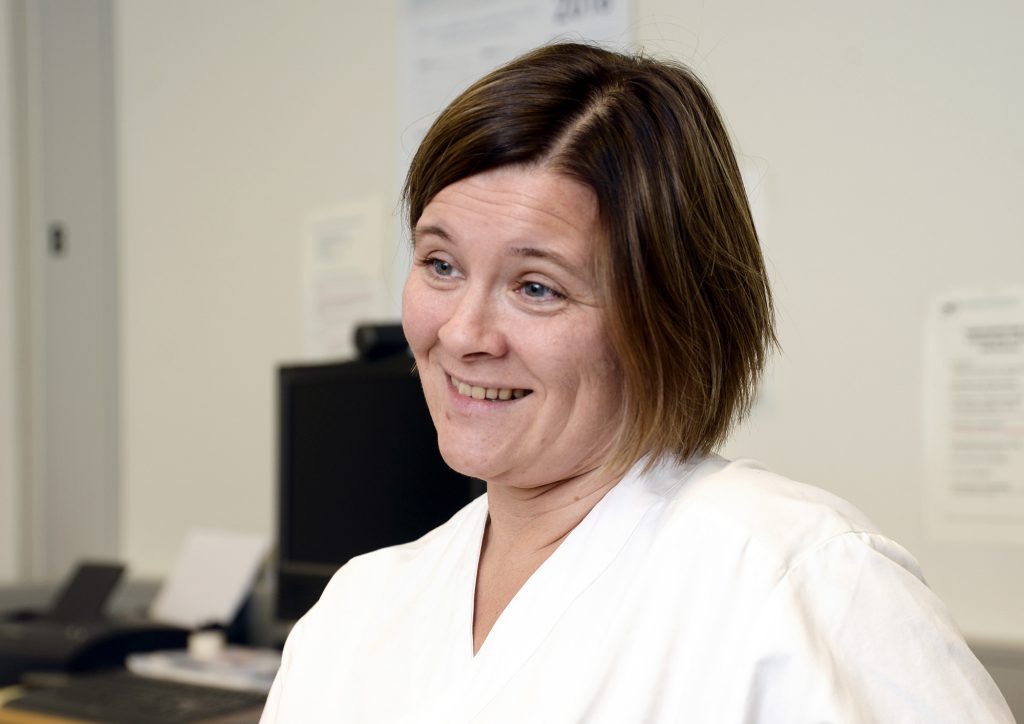 En kvinne som smiler til kameraet