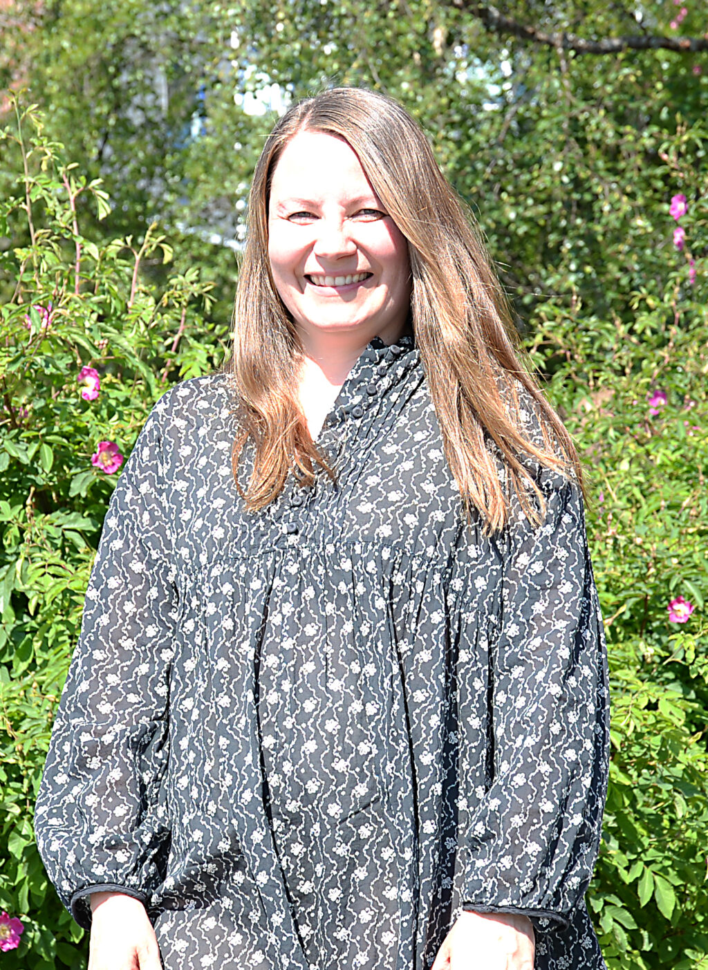 En kvinne som smiler til kameraet