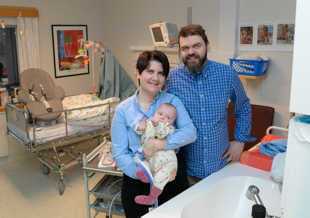 En mann og en kvinne som holder en baby