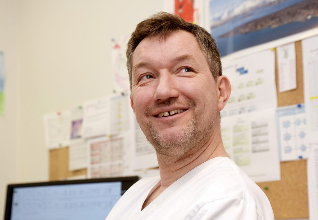 En mann som smiler til kameraet