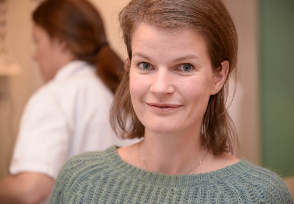 En kvinne som smiler til kameraet