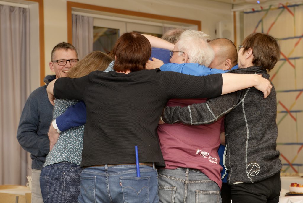 En gruppe mennesker som klemmer