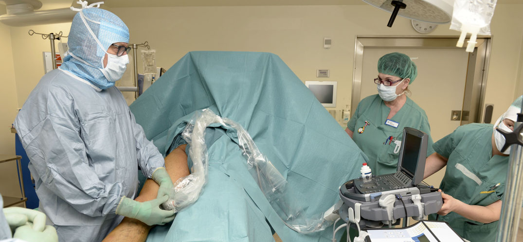 Kirurg Lars Knutson ved UNN Narvik er i gang med laseroperasjonen, og benytter ultralyd som nødvendig hjelpemiddel for å kvalitetssikre inngrepet. Spesialsykepleier Tove Birkeland følger med til høyre mens hun passer på pasienten. Foto: Per-Christian Johansen