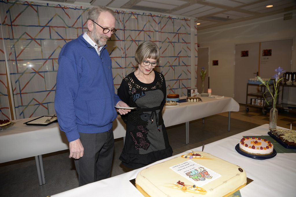 En mann og en kvinne står ved siden av et bord med mat på