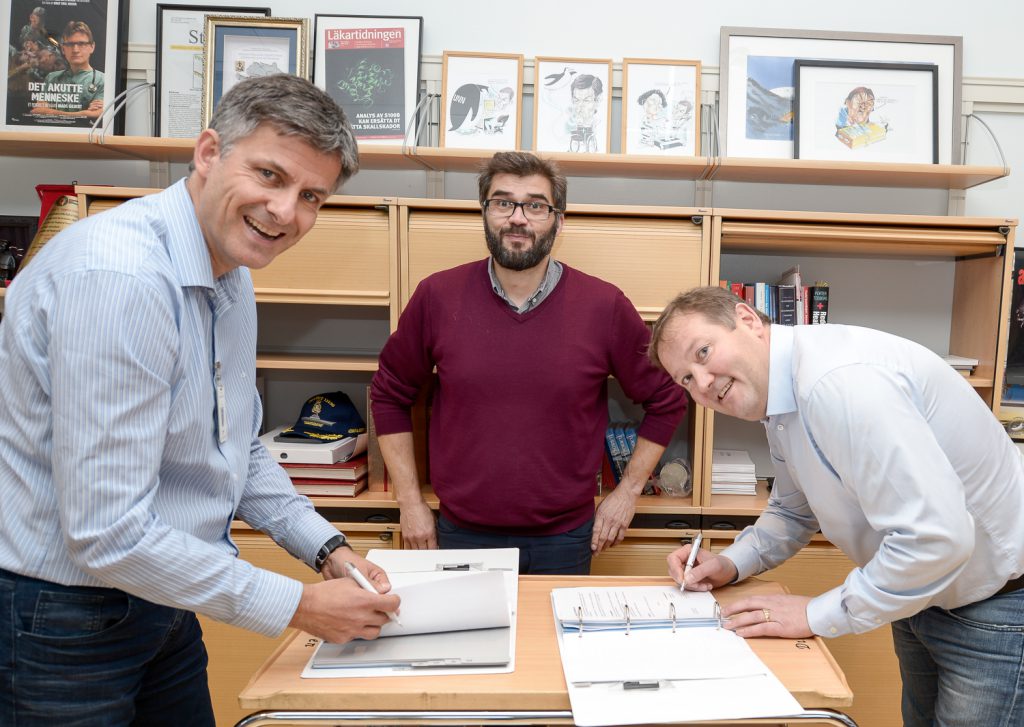 En gruppe menn som ser på en bok